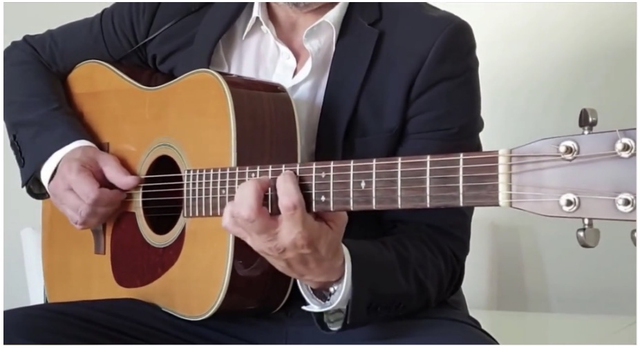 man strumming on guitar